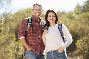 Couple with dentures smiling on a hike