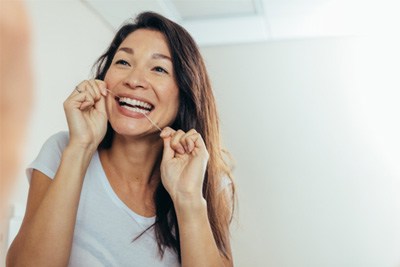 closeup of woman flossing teeth