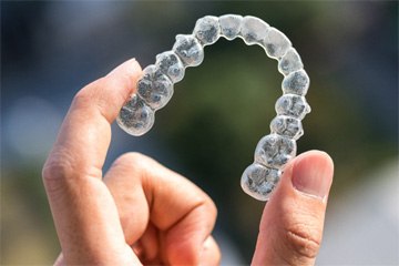 Patient holding up Invisalign in Tustin