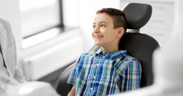 Smiling young dental in dental chair for children's dentistry