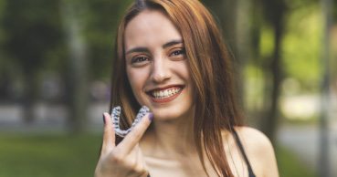 Woman smiling with invisalign aligner tray