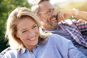 Man and woman with veneers in Tustin smiling