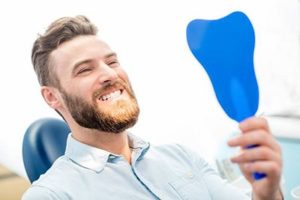 Man in dentist’s chair looking in mirror