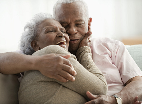 older person with dentures embracing partner