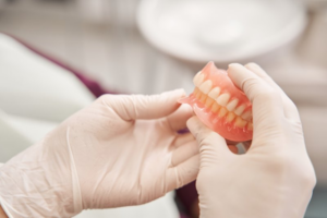 Dentist gently holding a pair of dentures